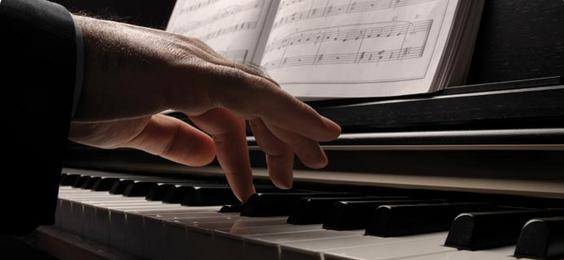Close-up of fingers playing piano keys.