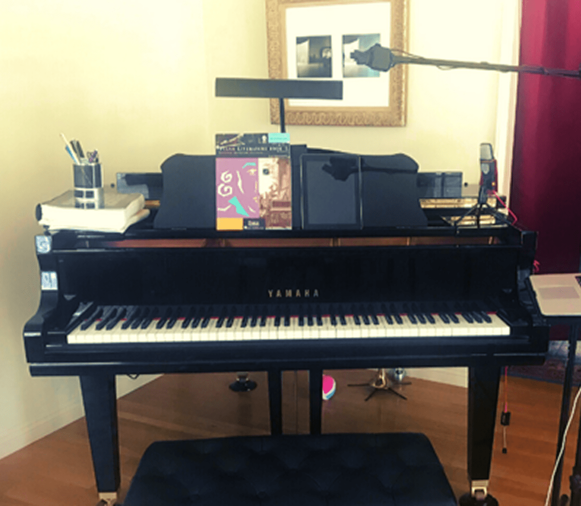 Piano with sheet music and microphone setup.