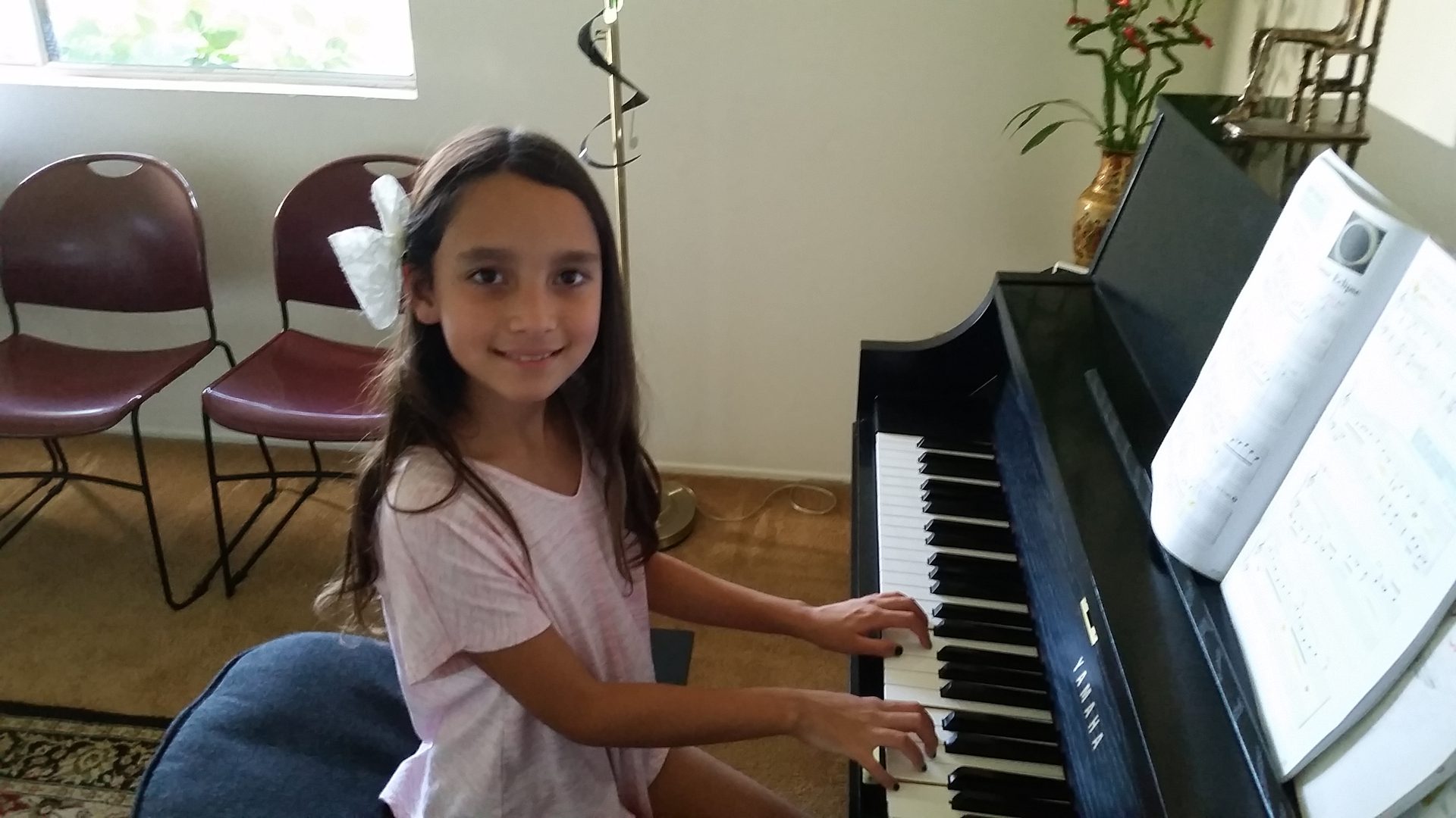 A young girl playing the piano indoors.
