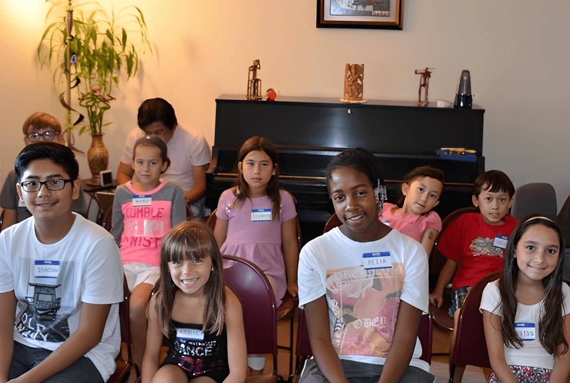 Children gathered indoors, some sitting and some standing, engaged in an activity.